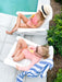 Two girls sitting by the pool on white children's Adirondack Chairs
