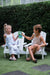 kids play on white timber children's Adirondack chairs by My Little Manor