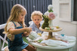 Young girl and boy play garden tea party with My Little Manor Round Dining table and chairs