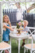 Young girl and boy play garden tea party with My Little Manor Round Dining table and chairs