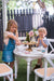 Kids have garden party on white cross back chairs and round table