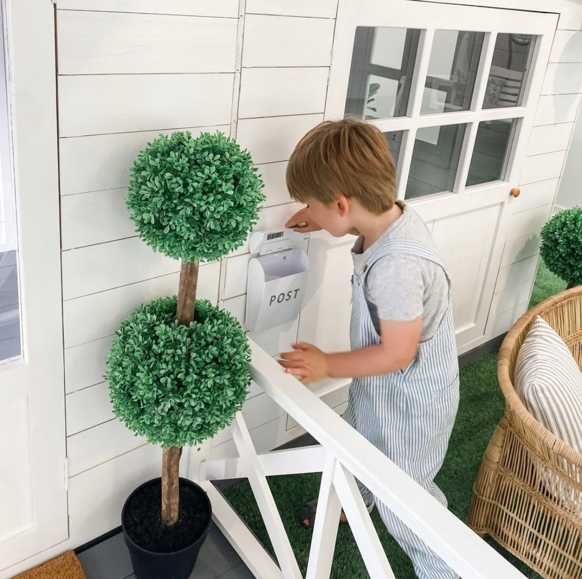 Young boy plays with toy letter box on cubby house