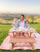 Mum and daughters sit outside in the garden on My Little Manor Outdoor Bench Seat Set