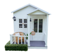 White cubby house with double gable roof and veranda sits on white transparent background. Kids Malawi arm chair sits on veranda