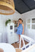 Young girl plays with wooden telephone attached to wooden white play kids kitchen inside timber white and grey cubby house