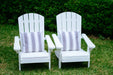 Two white timber Adirondack chairs with grey and white cushions sit on green grass.