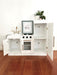 Children's Hamptons shaker style white play kitchen with gold fixtures and decorated with easter decorations. Cupboards open. White toy kitchen