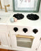 Children's Hamptons shaker style white play kitchen with gold handle, black oven knobs and black hotplates